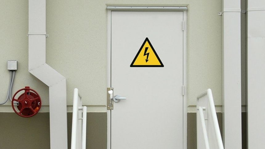 Ajtó ipari területen, figyelmeztető matricával