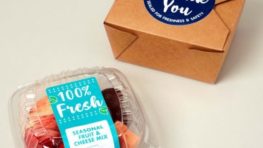 Elviteles doboz biztonsági zárral és egy műanyag doboz gyümölcssalátával, "100% Fresh" címkével.