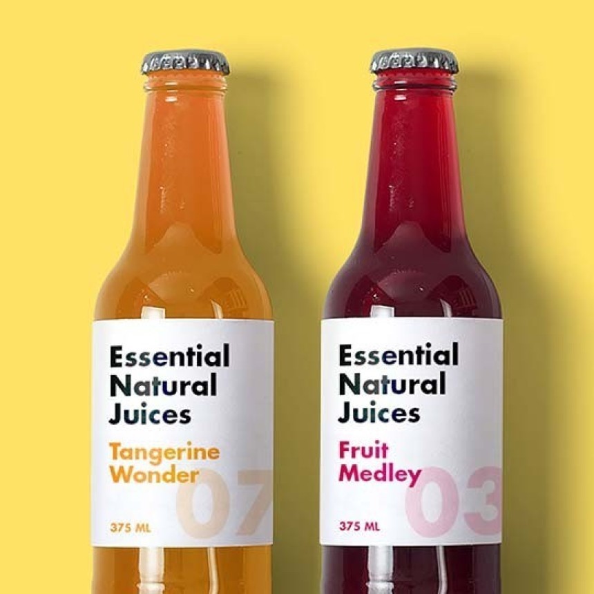 Két üveg „Essential Natural Juices” gyümölcslé sárga háttér előtt: balra narancssárga ital „Tangerine Wonder”, jobbra sötétvörös ital „Fruit Medley”, mindkettő 375 ml-es, fehér címkével.