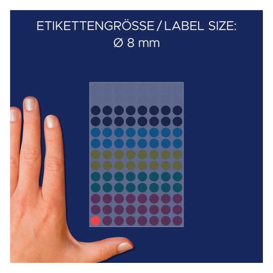 A képen egy kéz látható egy kör alakú matricákat tartalmazó lap mellett, amelyen a matrica mérete, 8 mm, felül van feltüntetve. A matricák sorokban és oszlopokban vannak elrendezve, különböző színeket bemutatva, beleértve egy piros pontot a bal alsó sarokban.