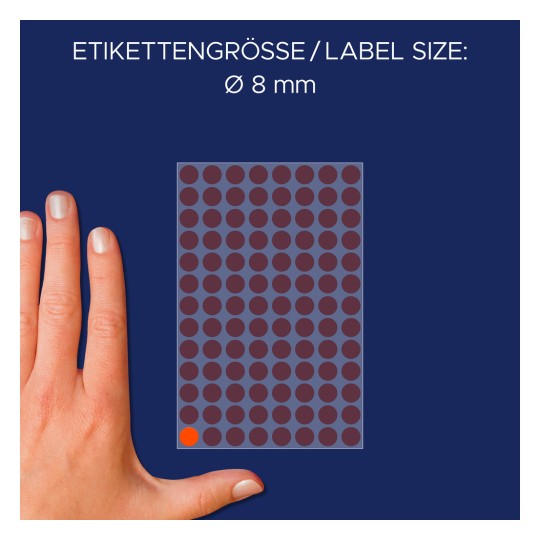 A kép egy kéz látható egy öntapadós címkékből álló ív mellett, ahol a címke mérete Ø 8 mm. A címkék rácsmintában vannak elrendezve, egy címke pirossal kiemelve.