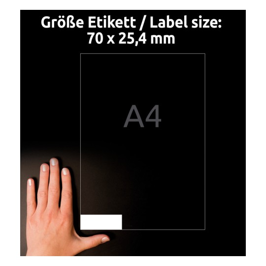 A kép egy kezet ábrázol egy 70 x 25,4 mm-es címkeméret-jelölés mellett sötét háttéren, egy A4 papír körvonalával.