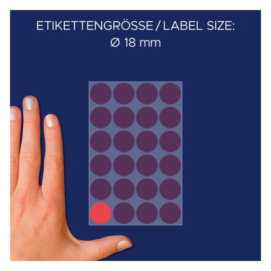 A kép egy kéz mellett egy kör alakú címkékkel ellátott lapot ábrázol, amely a címkék 18 mm átmérőjét jelzi. A lapon több színes kör látható, egy piros kör pedig ki van emelve.