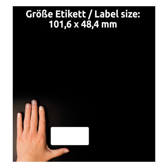 A kép egy kezet ábrázol, amely egy üres címke mellett van elhelyezve sötét háttérrel, a címke méretét pedig németül és angolul jelzi a szöveg.