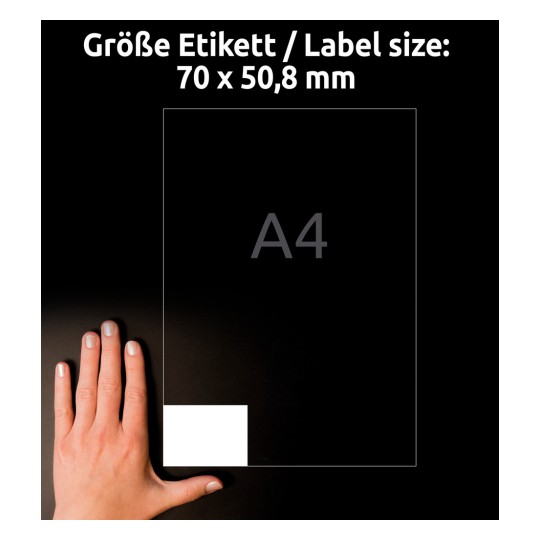 A kép egy kézben tartott A4-es papírt ábrázol, amelyen egy 70 x 50,8 mm méretű címke méretei láthatók. A háttér fekete, és szövegek jelzik a címke méretét és a papír formátumát.