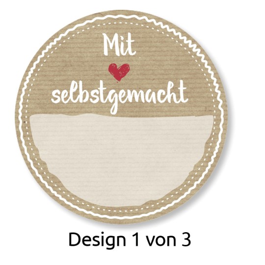 A kép egy kör alakú címkét ábrázol a következő szöveggel: 'Mit ❤️ selbstgemacht' (Szeretettel házi készítésű), alatta egy üres hely található. A dizájn texturált, bézs háttéren van dekoratív szegélyekkel. Van egy megjegyzés is, amely jelzi: 'Design 1 von 3' (1. dizájn a 3-ból).