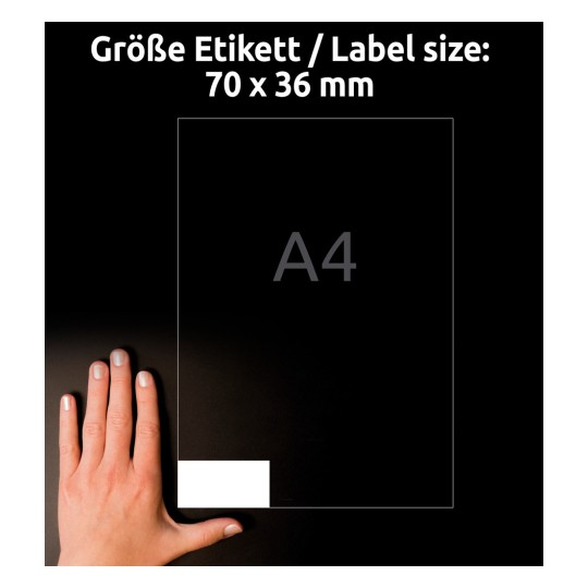 A kép egy kéz mellett egy címkeméretet mutat. A címke méretei 70 x 36 mm, és a háttérben egy A4-es papír található.