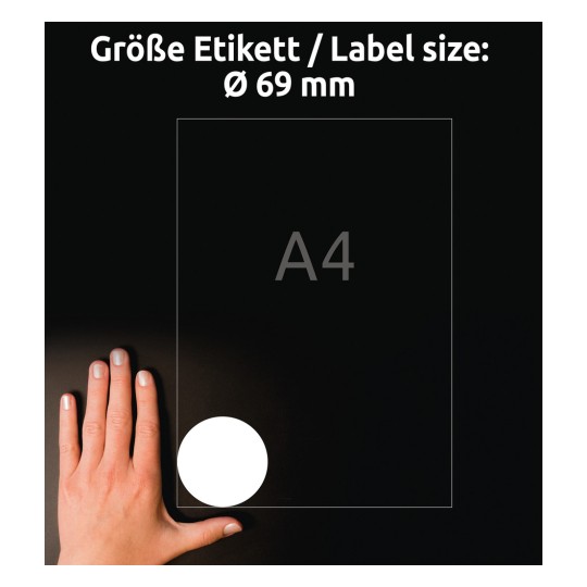 A kép egy kezet mutat, amely egy A4 méretű címke mellett van elhelyezve, a címkén pedig egy 69 mm átmérőjű kör alakú címke látható fehér színben, fekete háttér előtt.