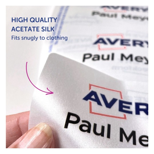 A kép egy magas minőségű acetát selyemből készült címkét mutat közelről. A "Avery" szót és a "Paul Meyer" nevet tartalmazza, hangsúlyozva, hogy szorosan illeszkedik a ruházathoz.