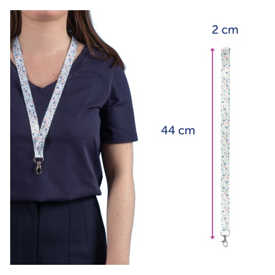 A képen egy személy látható, aki virágmintás nyakpántot visel a nyakában. A nyakpánt 44 cm hosszú és 2 cm széles, és olyan tárgyak, mint például kulcsok vagy jelvények tartására lett tervezve.