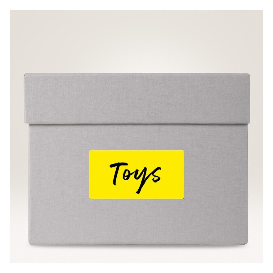 The image shows a grey storage box with a yellow label that says 'Toys'.