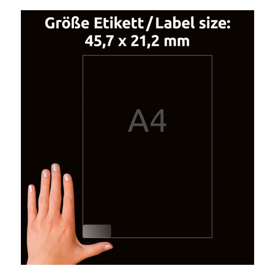 A képen egy kéz látható, amely egy 'A4' feliratú átlátszó lapot tart, rajta a méretek németül vannak feltüntetve: 'Größe Etikett / Label size: 45,7 x 21,2 mm'. A háttér fekete.