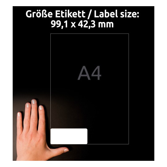 A képen egy kéz egy 99,1 x 42,3 mm-es méretű címkét tart, amelyen az "A4" felirat szerepel. A háttér sötét, és a címke az alsó részén helyezkedik el.