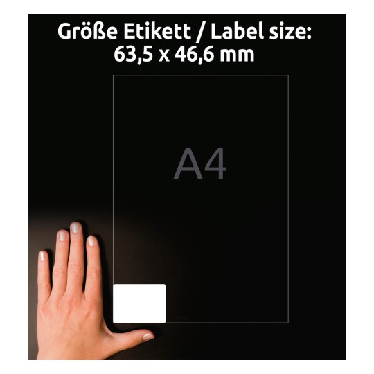 A kép egy kéz mellett mutat egy címke méretét jelző útmutatót, amely egy A4-es lap hátterén 63,5 x 46,6 mm-es méretekkel van feltüntetve.