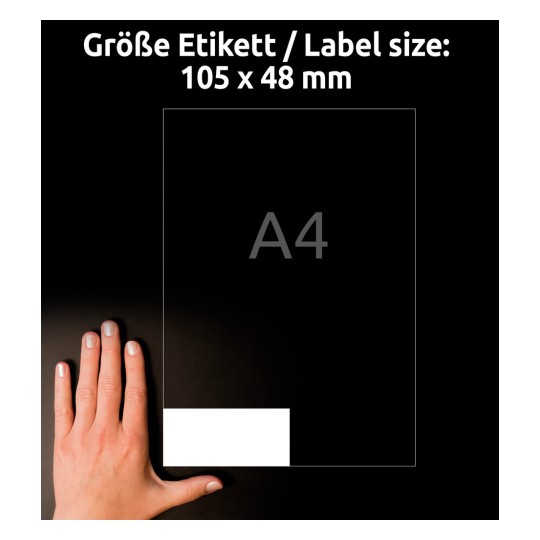 A kép egy kéz és egy címkesablon mellett látható, amely jelzi a címke méretét 105 x 48 mm-ként, A4-es papírral való összehasonlítással.