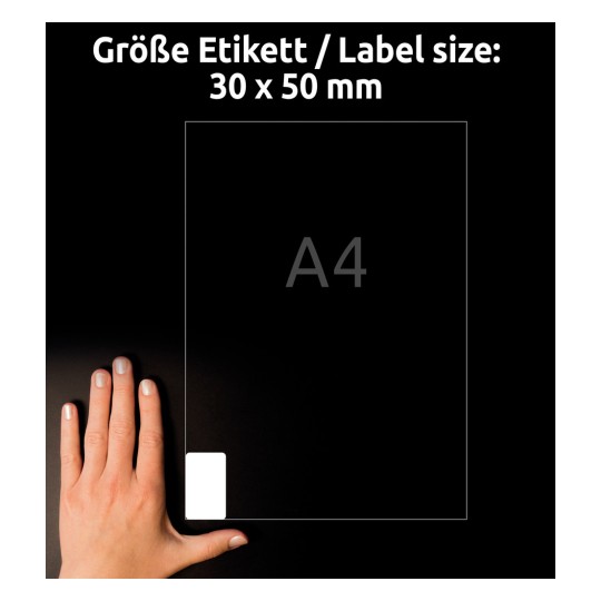 A kép egy A4-es méretű dokumentumot ábrázol, amelyen 30 x 50 mm-es címke található, és egy kéz tartja. A háttér sötét, kiemelve a kezet és a papírt.