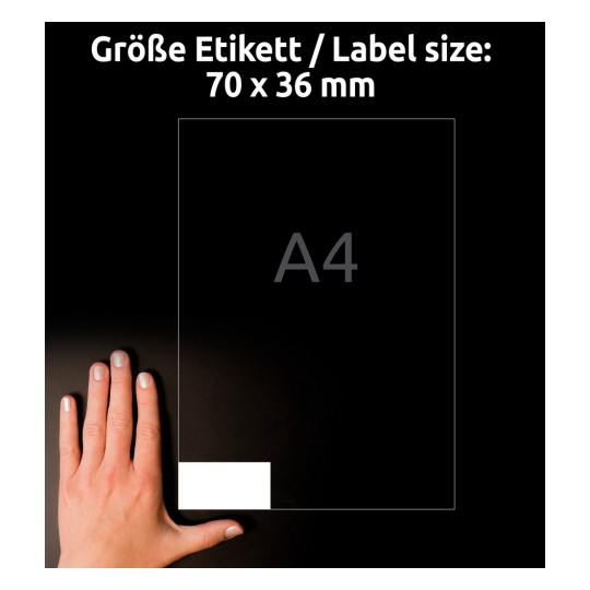 A kép egy kéz által tartott címkeméret-útmutatót ábrázol, amelyen a 70 x 36 mm méret van feltüntetve, a 'A4' betűk vastagon vannak kiemelve. A háttér sötét, kiemelve a címkeméretet.
