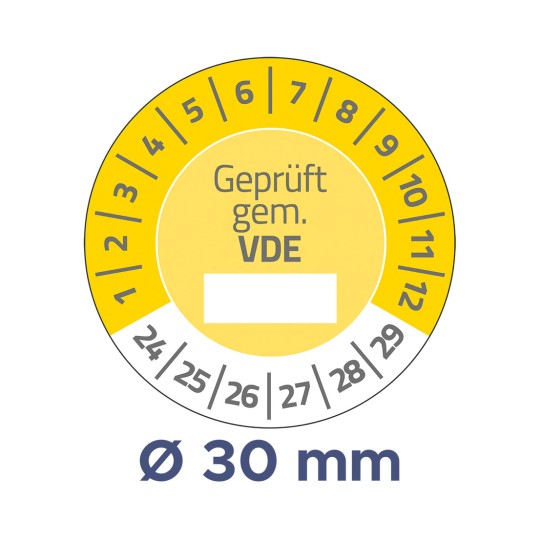 A képen egy kör alakú mérőműszer látható sárga háttérrel, amely méréseket jelez, középen a 'Geprüft gem. VDE' felirattal, valamint 1-től 30-ig terjedő számokkal a szélén. Az átmérője Ø 30 mm.