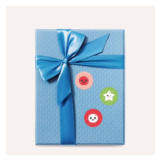 A képen egy kék ajándékdoboz látható, amelyet egy fényes kék szalag és három színes matrica díszít, rajzfilmszerű mintákkal.