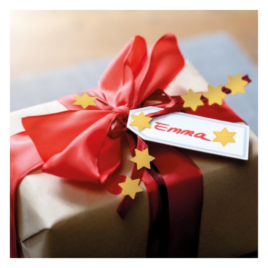 Egy szépen becsomagolt ajándék barna papírba, amelyet piros szalag és arany csillag díszítések ékesítenek, és egy címkével van ellátva, amelyen az 'Emma' felirat szerepel.