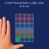 A kép egy kéz látható egy ívnyi különböző színű kör alakú címkék mellett, amelyek 18 mm-es címkeméretet jelölnek.
