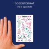 A képen egy kéz látható, amely egy színes ideiglenes tetoválásokkal teli lapot tart. A lapon különféle virágos és dekoratív minták találhatók élénk színekben, a tetején pedig a 'Tattoo' szó olvasható.
