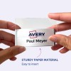 A képen egy személy látható, aki egy névjegyet tart az Avery logóval és a 'Paul Meyer' névvel. Úgy tűnik, hogy a névjegyet könnyű behelyezni egy erős papír anyagból készült tartóba.