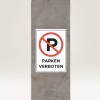 A kép egy betonpilléren elhelyezett táblát mutat, amely jelzi, hogy parkolni tilos. A táblán egy 'P' betűn áthúzott piros kör található, valamint a "PARKEN VERBOTEN" felirat vastag betűkkel.