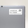 A kép egy tablet vagy laptop hátulját mutatja, amelyen egy címke található. A címkén az 'INVENTAR Nr. 123456' felirat látható, ami a leltári információkra utal, valamint az 'Avery Zweckform' márkanév és egy cím szerepel.