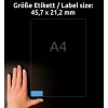 A kép egy kezet mutat egy címke mellett, amely 45,7 x 21,2 mm méretű, utalva annak méretére egy A4-es laphoz viszonyítva.