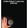 A kép egy kéz helyzetét mutatja egy kör alakú címke közelében, sötét háttérrel, a címke mérete pedig Ø 80 mm, fehér szöveggel jelölve.