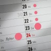 Egy naptárlap, amelyen a 20-tól a 26-ig terjedő dátumok láthatók, és bizonyos napok kiemelve vannak. A 24-én szerepel a 'Péter' név, amit rózsaszínnel bekarikáztak, jelezve valamilyen jelentős eseményt.