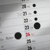 Egy naptárlap, amelyen dátumok láthatók, és a 24-én 'Péter' van írva. Több más dátum fekete körökkel van megjelölve.