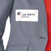 A képen egy személy látható, aki szürke zakót visel, melyen egy névtábla van, amin a következő felirat olvasható: 'Julia SMITH Marketing'.