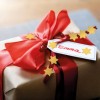 Egy szépen becsomagolt ajándék barna papírba, amelyet piros szalag és arany csillag díszítések ékesítenek, és egy címkével van ellátva, amelyen az 'Emma' felirat szerepel.